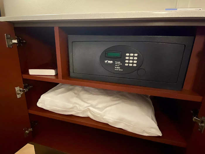Upon opening the cabinet, I found some hotel-room staples: a safe, an extra pillow, and a Bible.