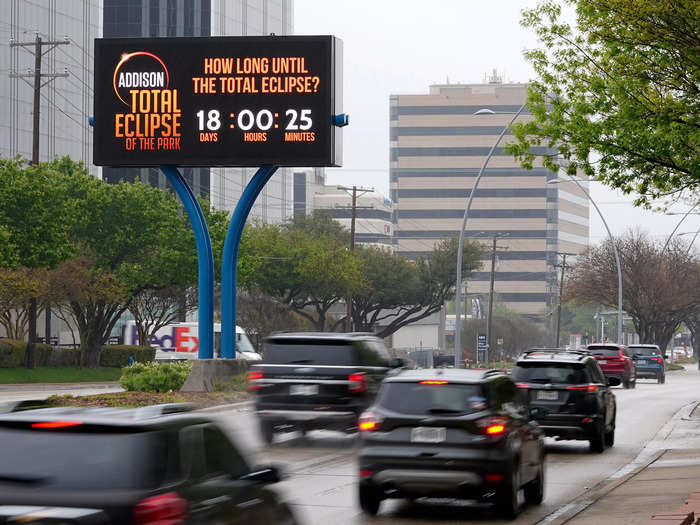 Community festivals and viewing events will provide an added boost to local economies. A digital billboard promotes the day on a busy road in Addison, Texas.