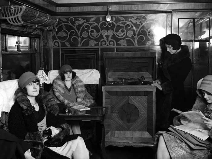 Passengers dressed to the nines in hats, gloves, and fur coats in a first-class London North Eastern Railway car in 1930.