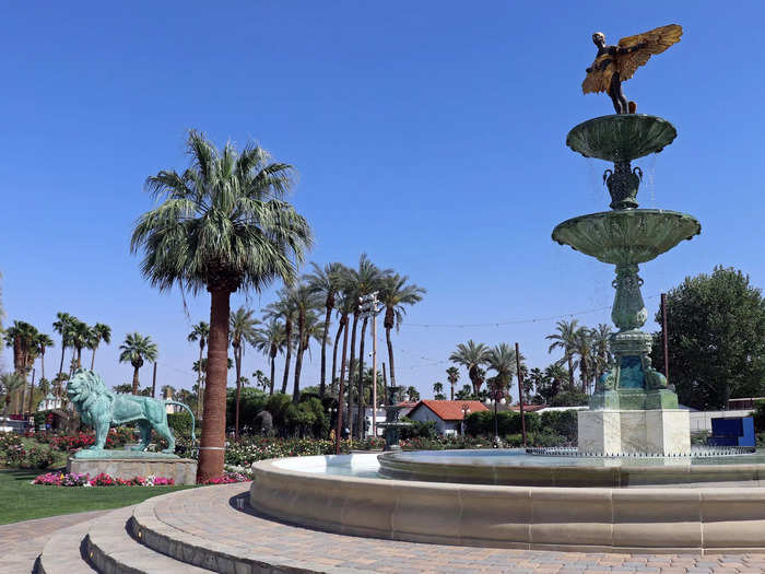 The beautifully manicured garden features several large fountains and statues.