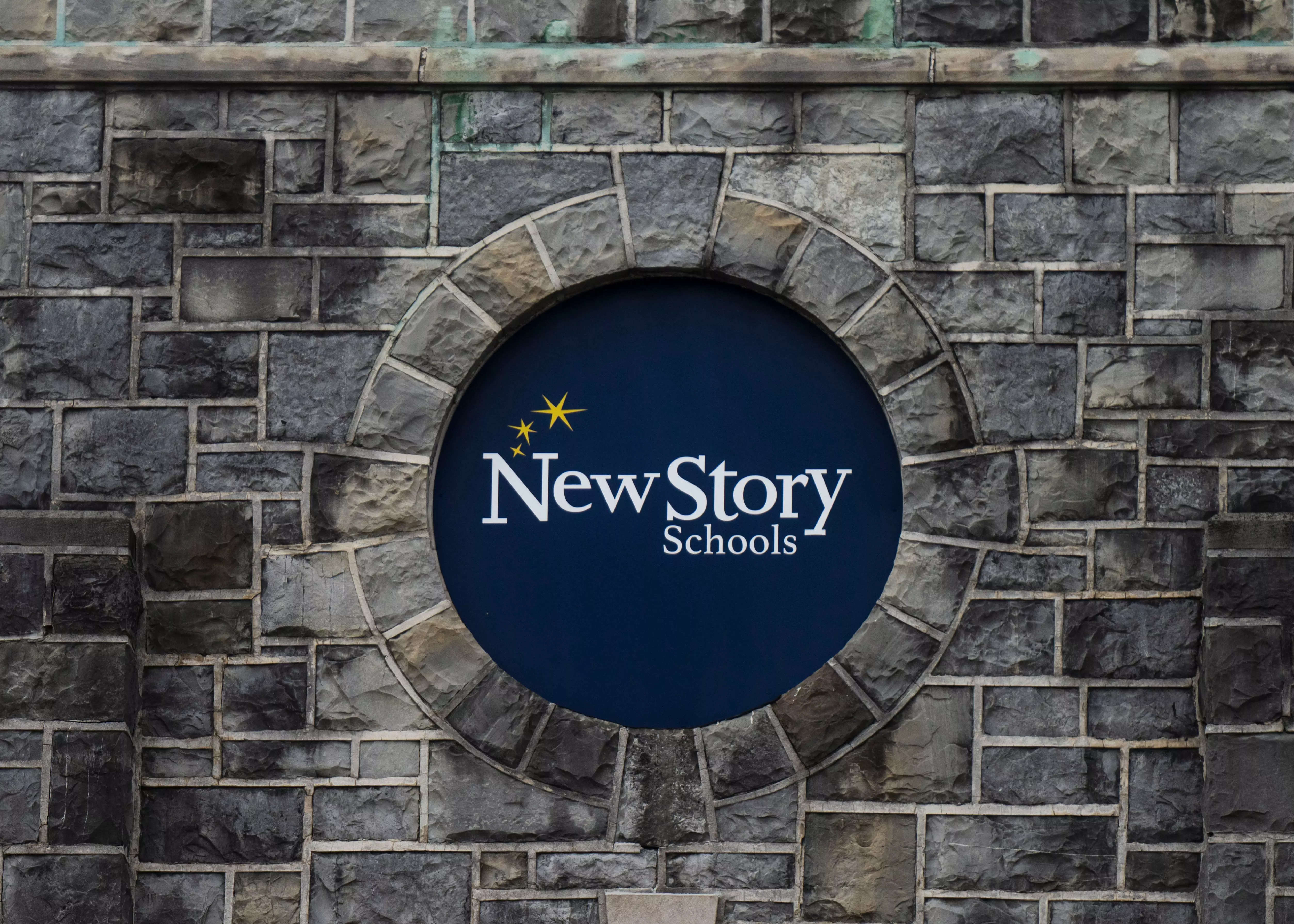 School sign on stone building for New Story Schools.
