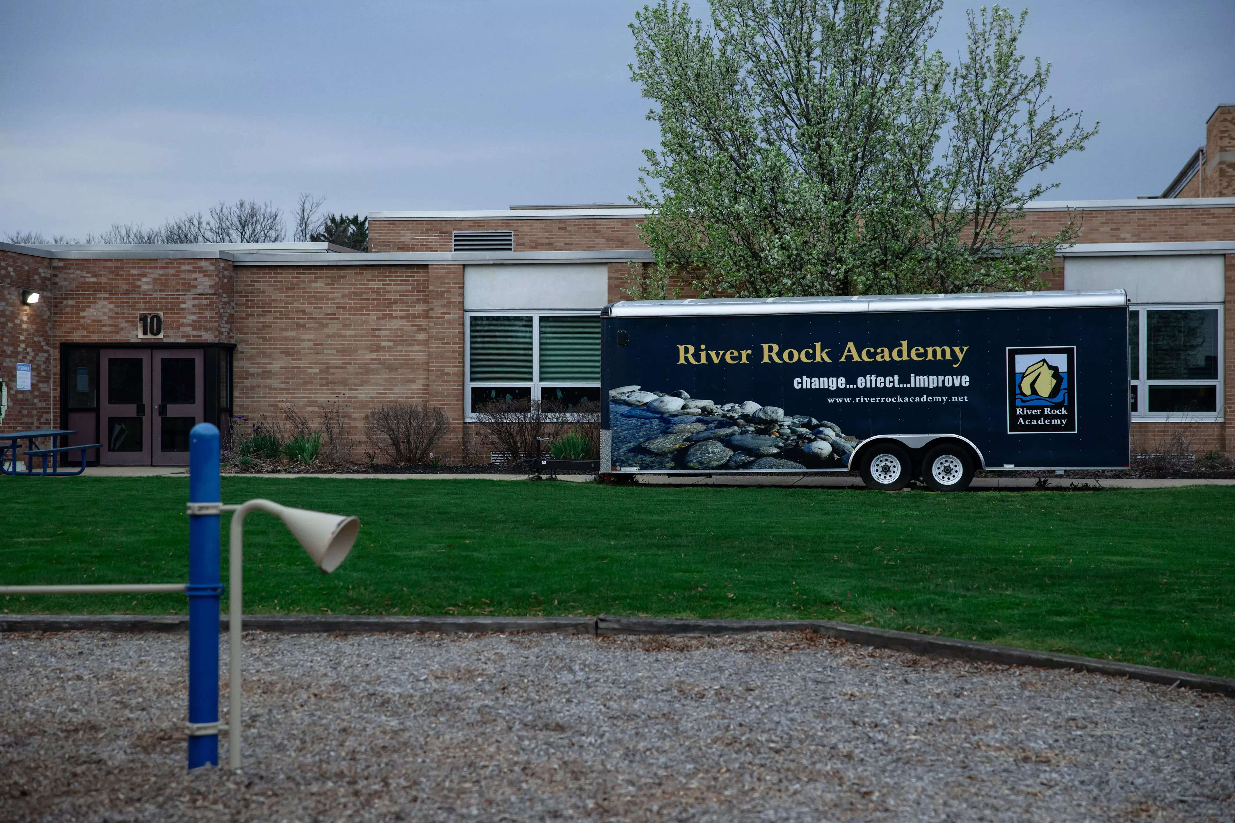 River Rock Academy vehicle in front of the school building.