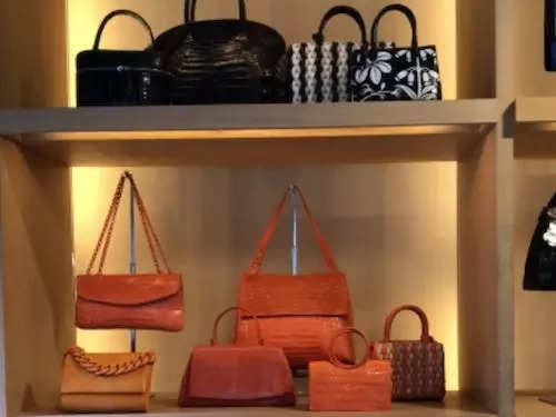 A photo of numerous handbags in many bright colors designed by Nancy Gonzalez and displayed on shelves in the Gzuniga Ltd. showroom.