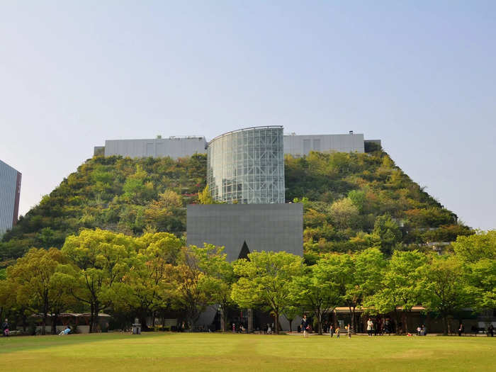 The roof of the ACROS Fukuoka Prefectural International Hall in Fukuoka, Japan, is covered in a forest of trees and plants.