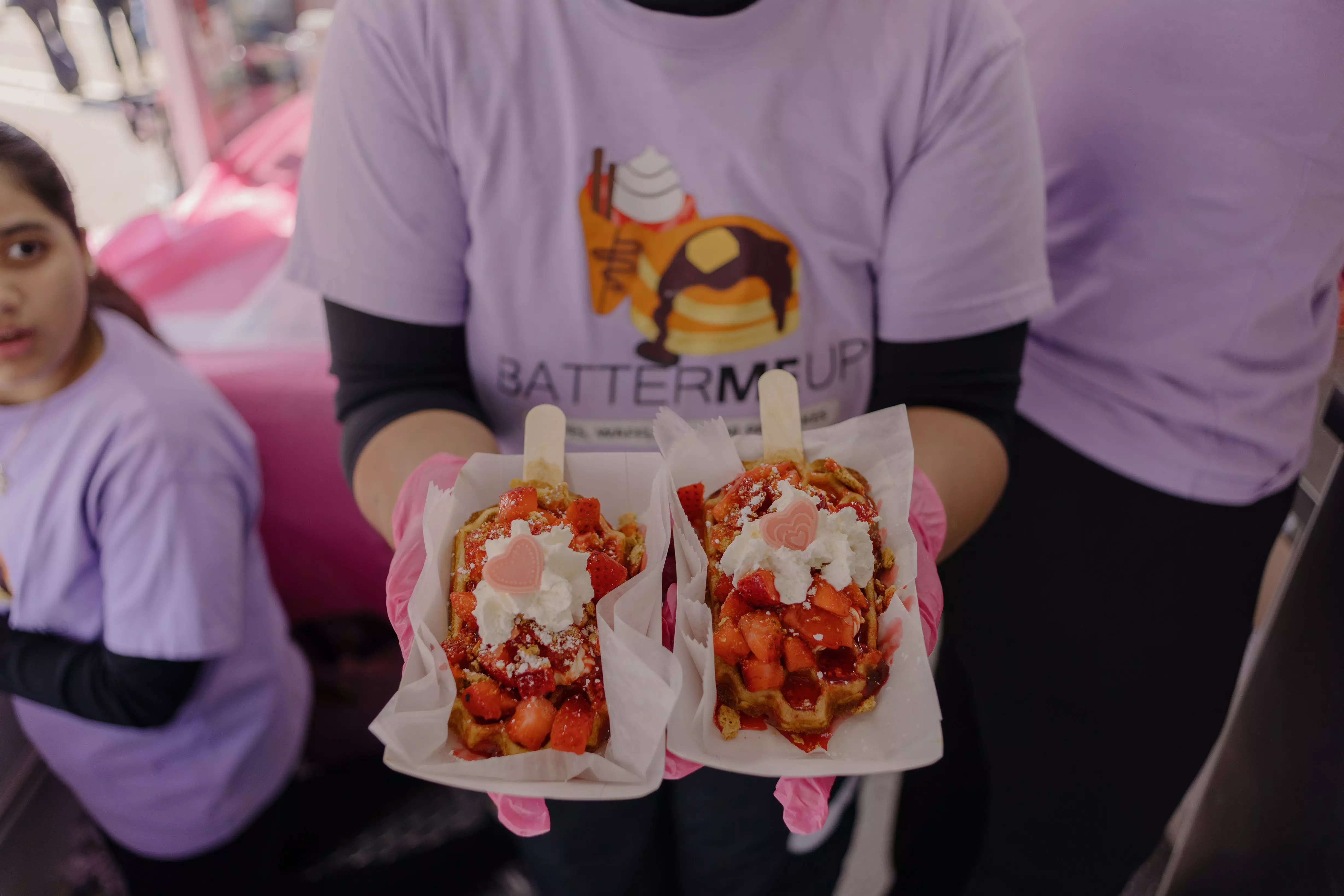Kathy Quiroga holds two strawberry cheesecake waffle treats
