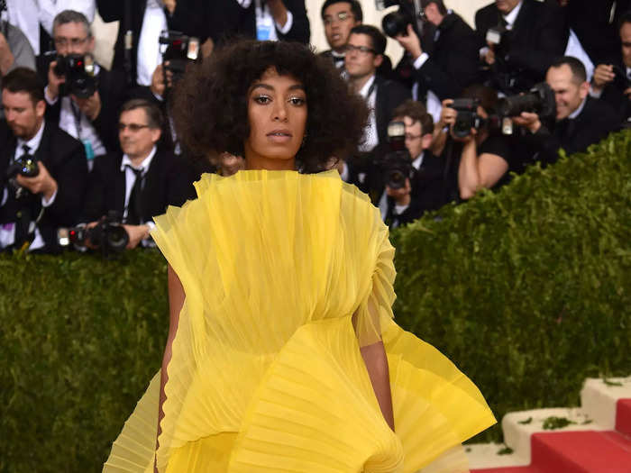 Solange dressed head to toe in a lemon-yellow ensemble by David Laport.