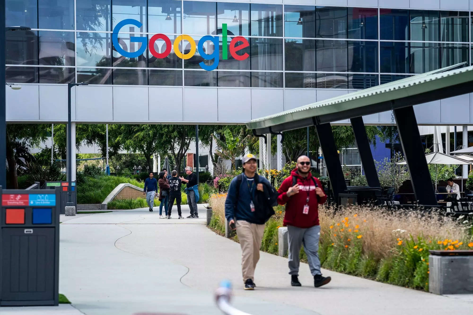 Google employees walk across the campus of the Googleplex, Google
