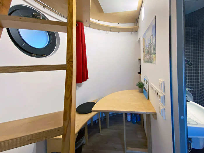 Inside, the 53-square-foot bottom level packed in a sitting area, a bathroom, and a ladder to the second floor.