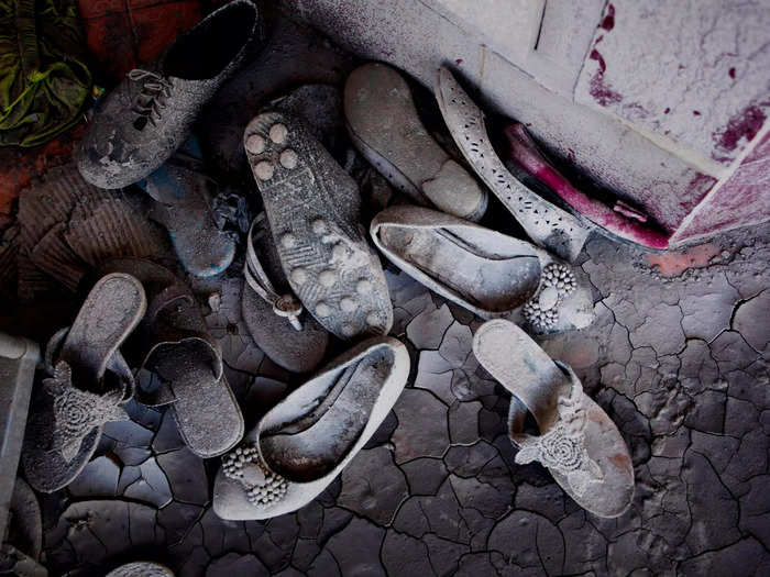 Shoes sit covered in ash and dust.