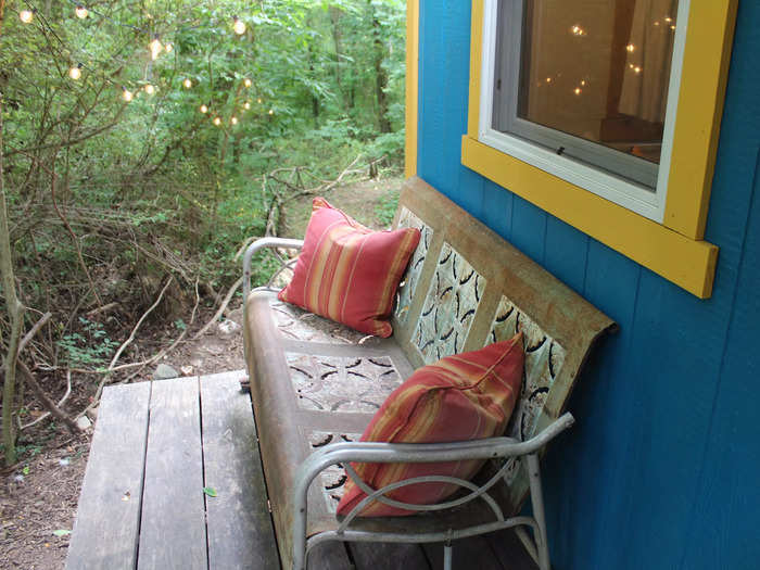 There was a bench with colorful cushions outside the tiny house.