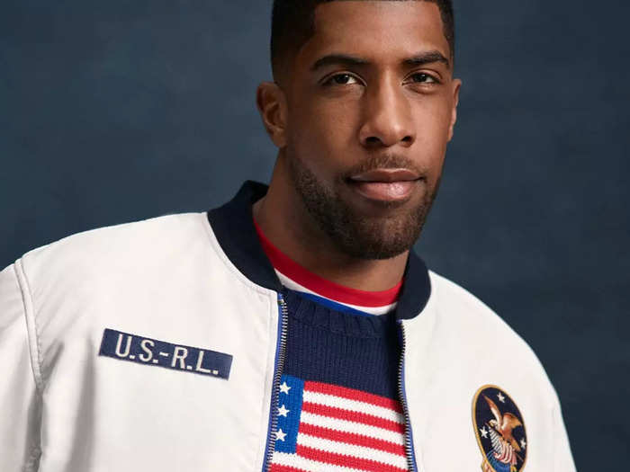 Paralympic swimmer Jamal Hill wears the Team USA reversible jacket and a knitted flag sweater.