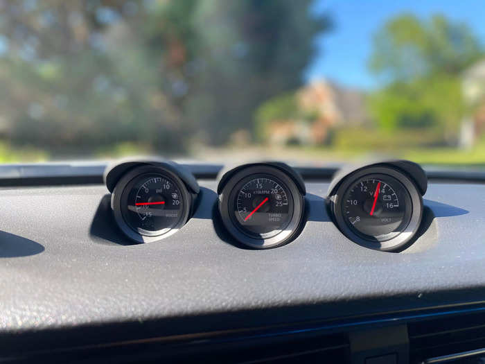 Sitting atop the dash is a set of three analog gauges. 