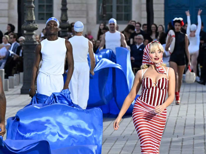 Sabrina Carpenter paid homage to 1940s swimwear in a red-and-white striped look from Jacquemus. Performers waved blue ribbons around her that looked like water. 