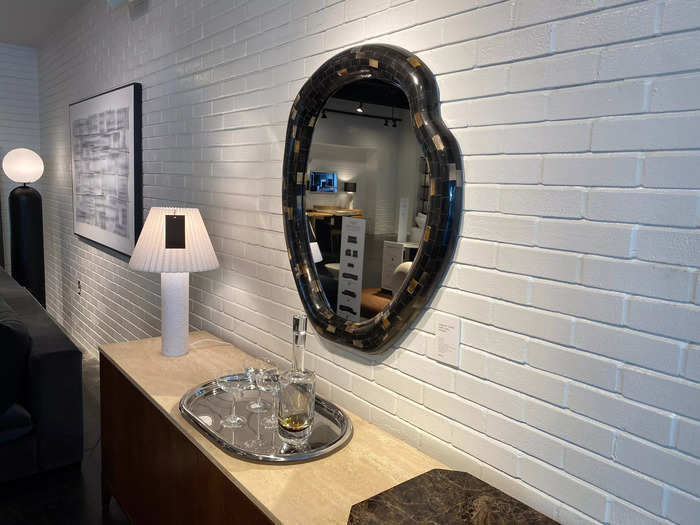 This black wall mirror has a horn frame that makes it a focal point. 