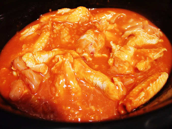 Then I added my chicken wings to the slow cooker and poured the sauce on top.