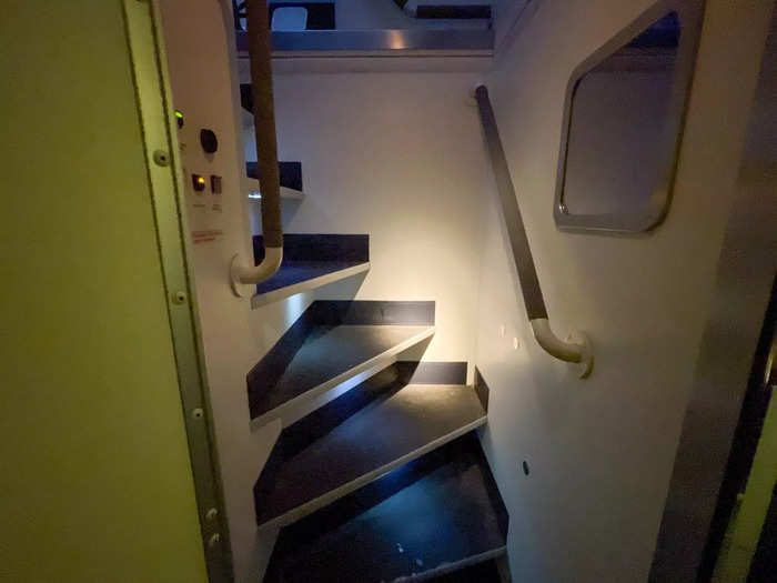 Each step was covered in a non-slip tread that led up to a bedroom for flight attendants. I grabbed onto the handrail and scaled the steps.