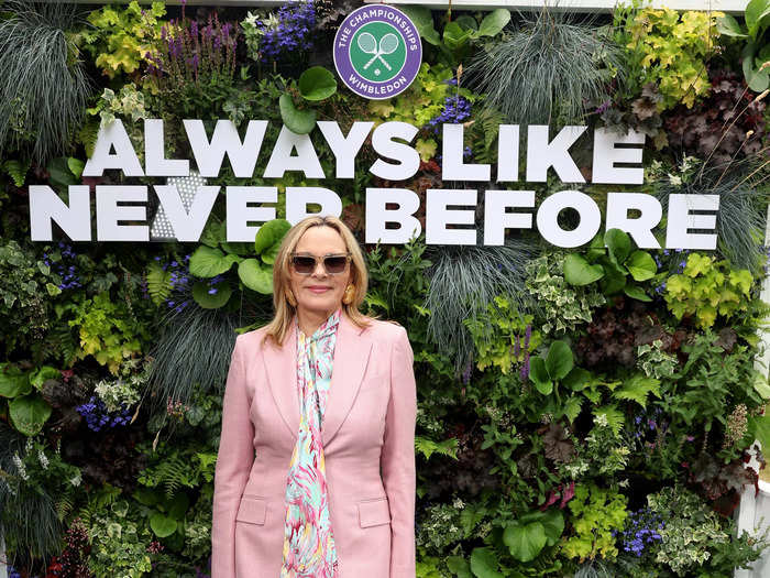 Kim Cattrall posed in a dusty-pink suit, floral blouse, and metallic heels.