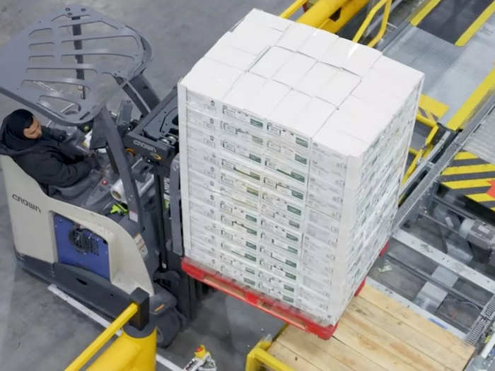 Forklift operators put arriving pallets into a machine that separates the boxes