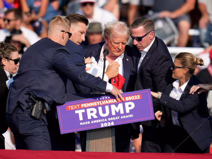 6:13 p.m. ET — Secret Service agents surrounded Trump as they began to usher him offstage