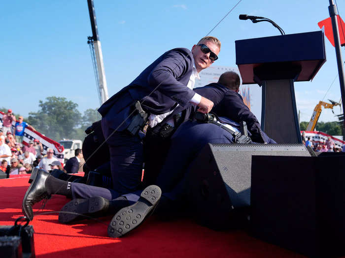 6:12 p.m. ET — Secret Service agents laid atop Trump onstage after he was shot at