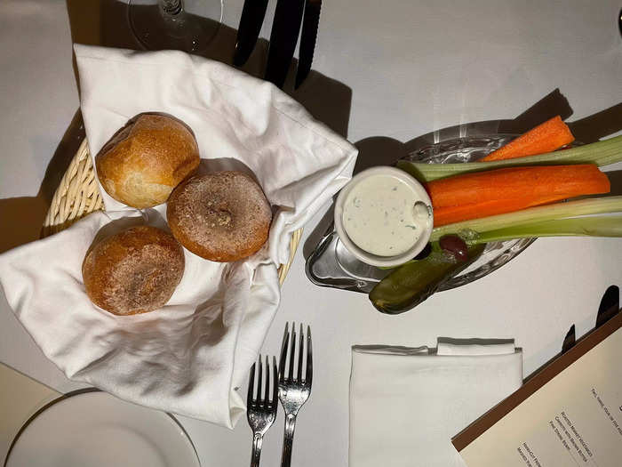 Before our meal, a basket of dinner rolls, a dish of butter, and a boat of crudités arrived.