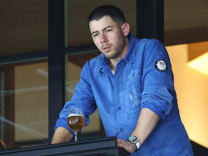 Nick Jonas was seen watching from the stands in a blue denim shirt featuring the Eiffel Tower.