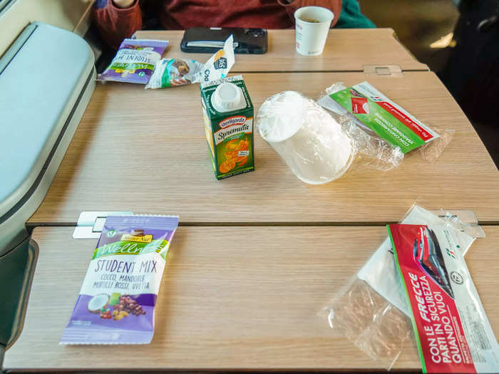 After the business-class train departed, attendants greeted passengers with complimentary snacks and drinks.