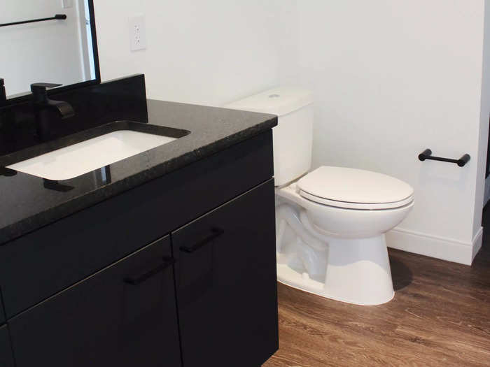 The apartment had a modern bathroom with black countertops and a rain shower.