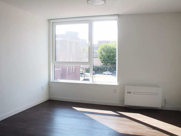 The bedroom was located off the living room and had a large window.