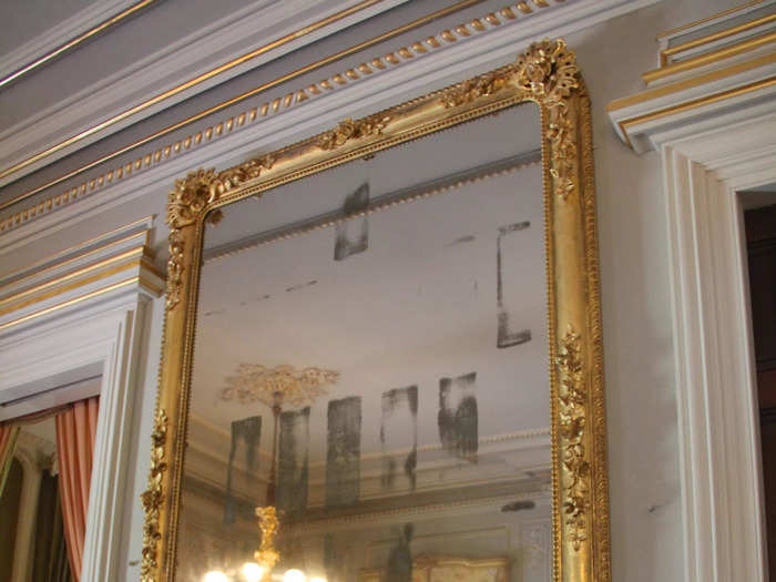 An enormous mirror reflected the ballroom