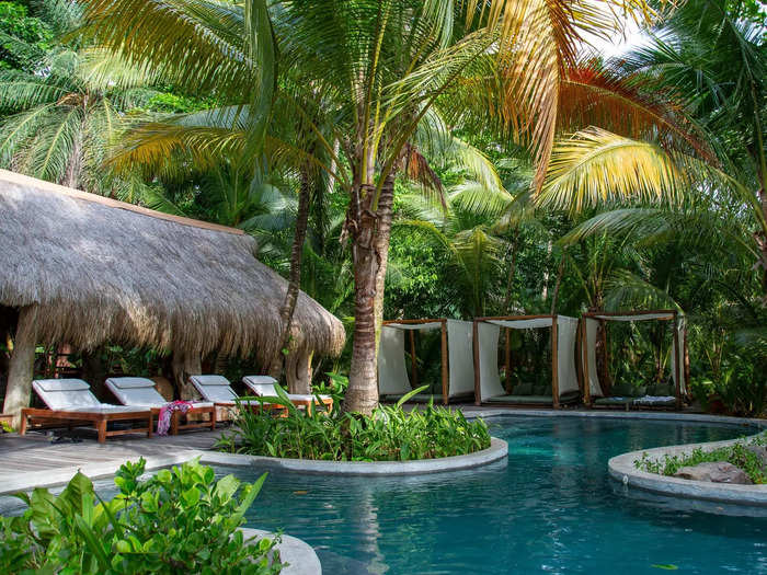 Shaded cabanas lined one area, and a pavilion with yoga mats and hammocks filled another.