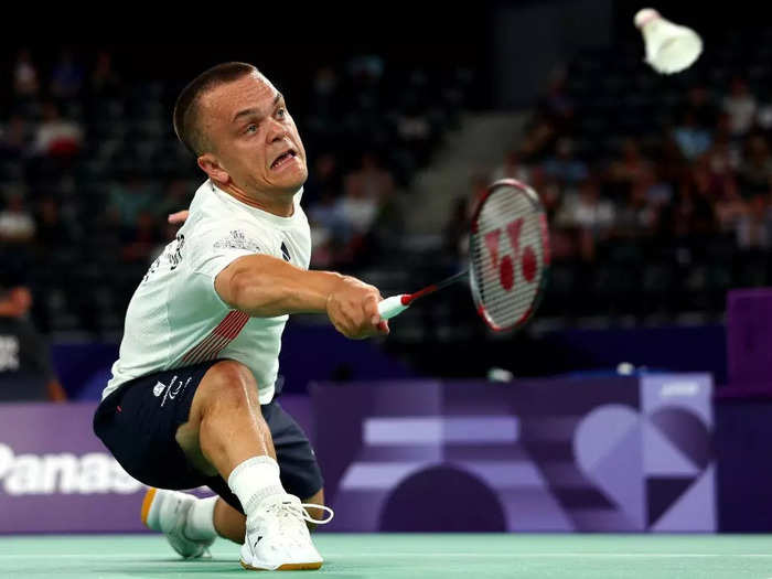 Jack Shephard of Great Britain dove to the ground in a badminton match against China as Mouhtaropoulos snapped photos.