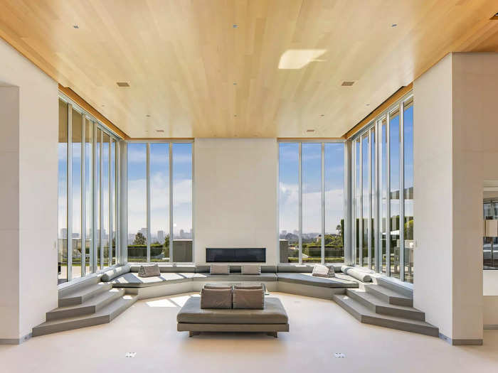 A living room showcases panoramic views of the city and one of the home