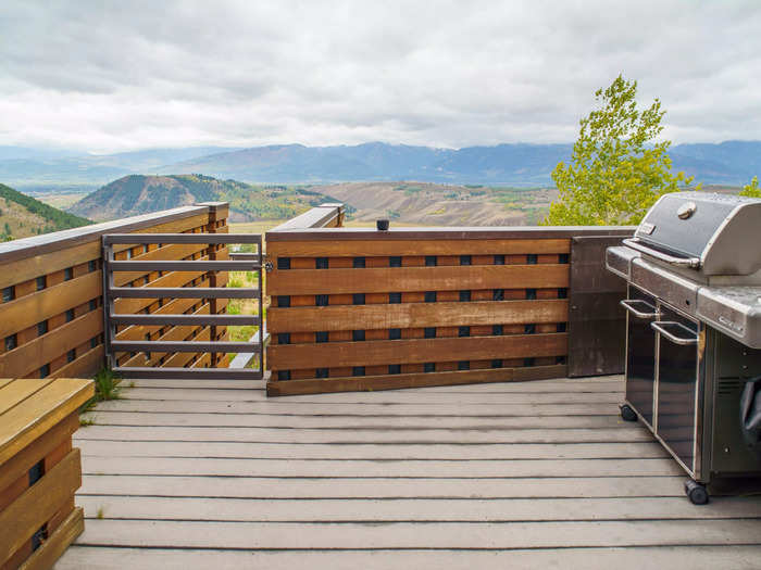 A door leads to an outdoor patio with a grill at the end of the kitchen. 