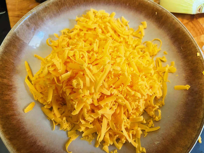 The sauce calls for 2 cups of shredded sharp cheddar cheese.