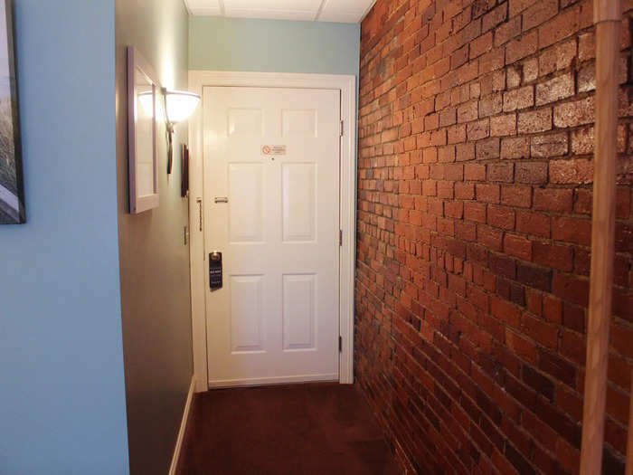 The entrance to our room was brightly lit and featured a large exposed brick wall.