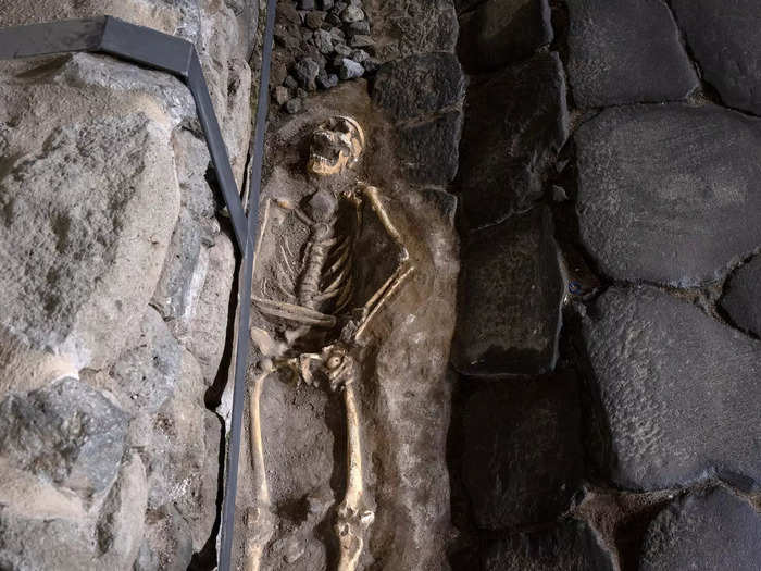 Between the stones of the road are casts of three 2,000-year-old twisted skeletons.