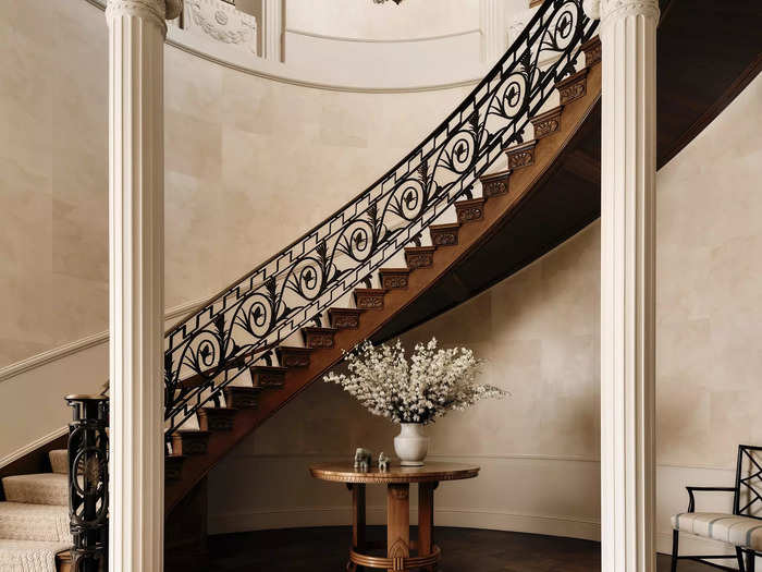 The main entrance greets guests with a spiral staircase and a grand entry hall with 14-foot ceilings.