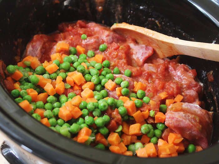 Next, add in all the other ingredients, including the tomatoes, peas, and carrots.