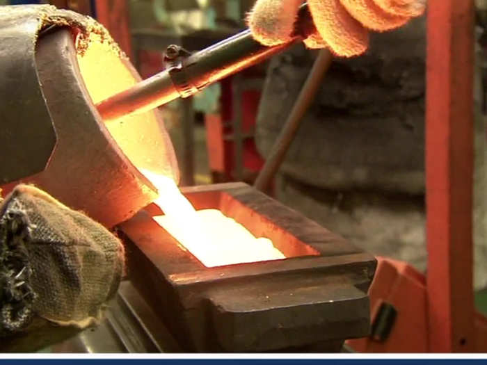 Workers use the crucible to transport the liquid gold, and pour it into a mold.