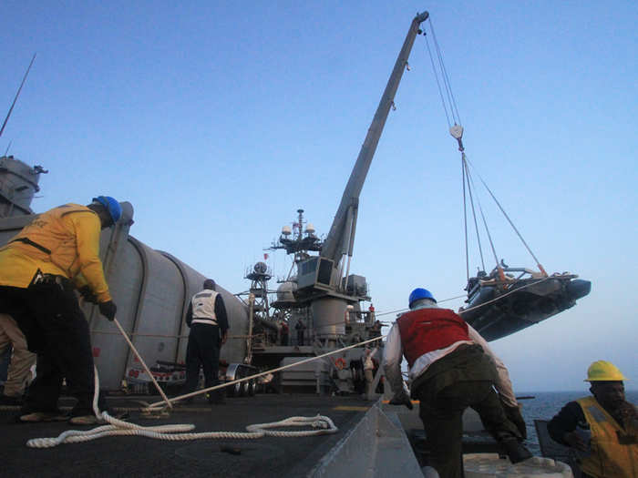 The Ponce brings on some troops, gear, and supplies from small boats and has cranes on both sides of the ship — this one for the larger boat