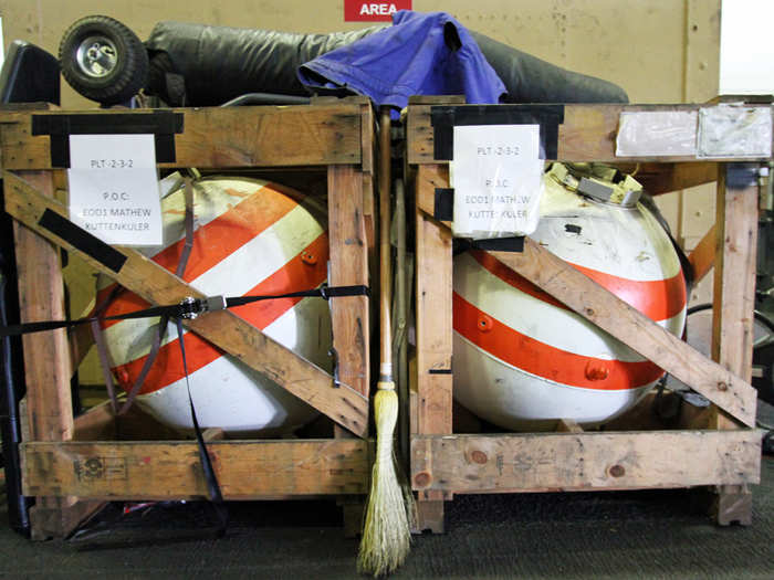 The magnetic field generated by the plates, buoys, cables, and weights will detonate magnetic mines that may look like these dummies found on the USS Eisenhower