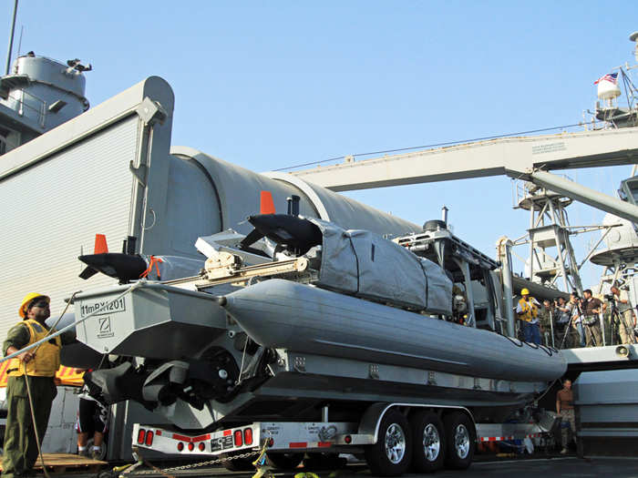 Back up on deck military and civilian crew are preparing to drop the D-Rib boat into the Gulf with two REMUS 100 submersible mine hunting drones