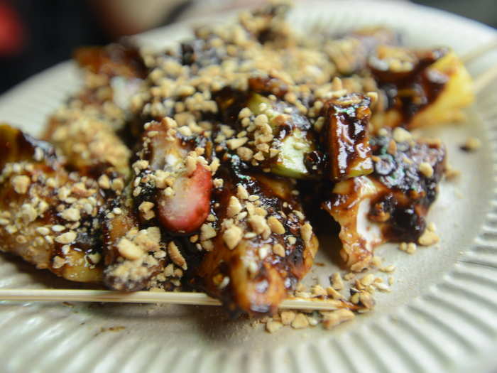 Pieces of skewered dough are fried, given a coat of shrimp paste, and topped with crushed peanuts in this Malaysian dish called Penang Rojak.