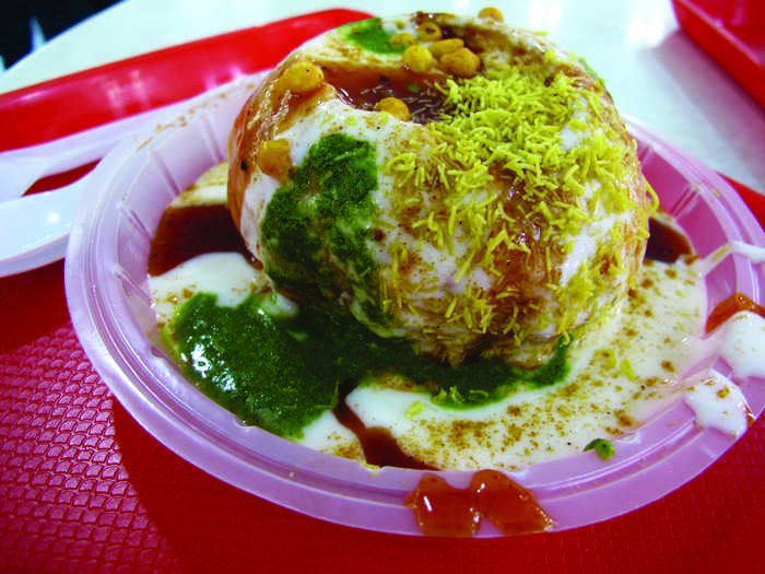 This ball of flavor is called Pata Puri, a crispy Indian potato puff topped with a number of different sauces.