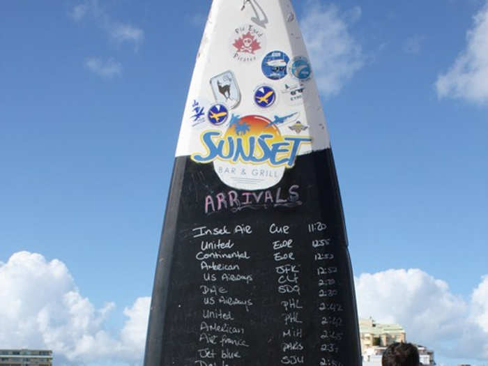 A local restaurant, the Sunset Bar and Grill, notifies everyone when to expect the next plane.