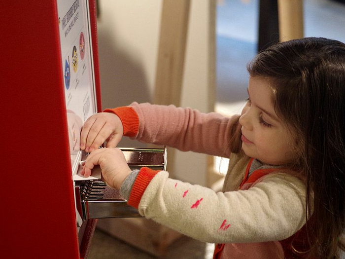 Here, a little girl explores a vending machine with Tattly temporary tattoos.