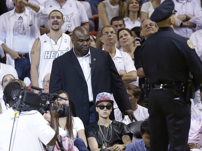 On Monday, he raised eyebrows sitting courtside at the Heat-Pacers series wearing indoor sunglasses, oversized Heat hat with a snakeskin brim, a leather baseball jersey, and gold chains.