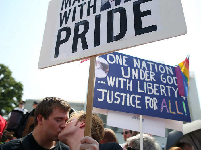 Married couple Michael Knaapen and John Becker share a kiss amidst activists