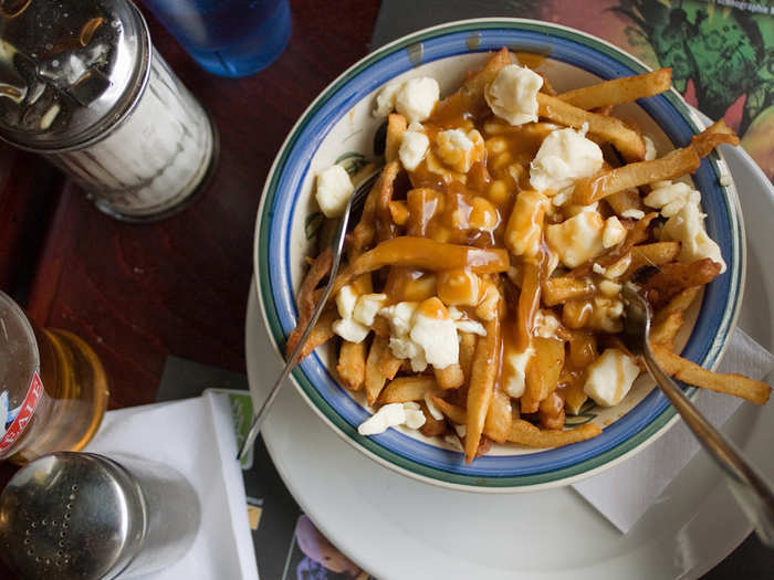 Chow down on poutine, a dish of crisp french fries with brown gravy and cheese curds, in Montreal, Canada. Locals recommend the poutine from La Banquise.